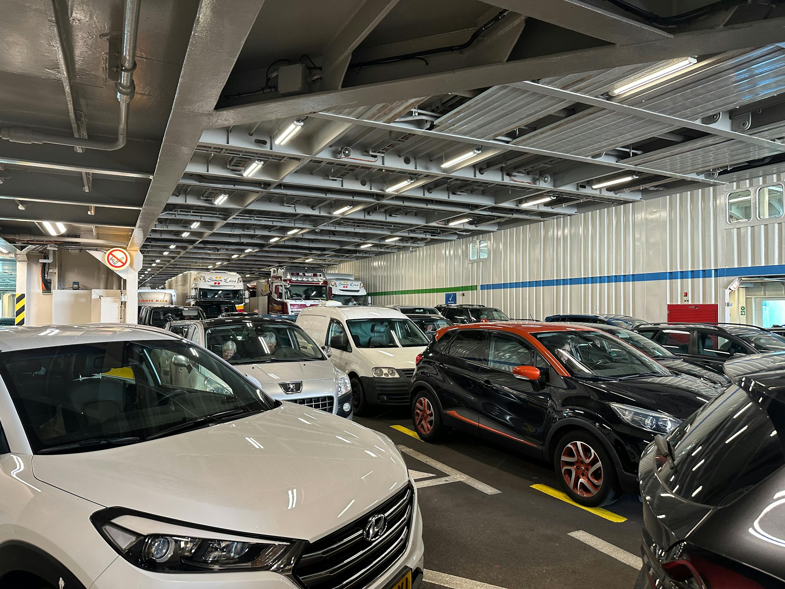Cars and trucks parked closely together on a ferry deck, emphasizing transportation and travel.